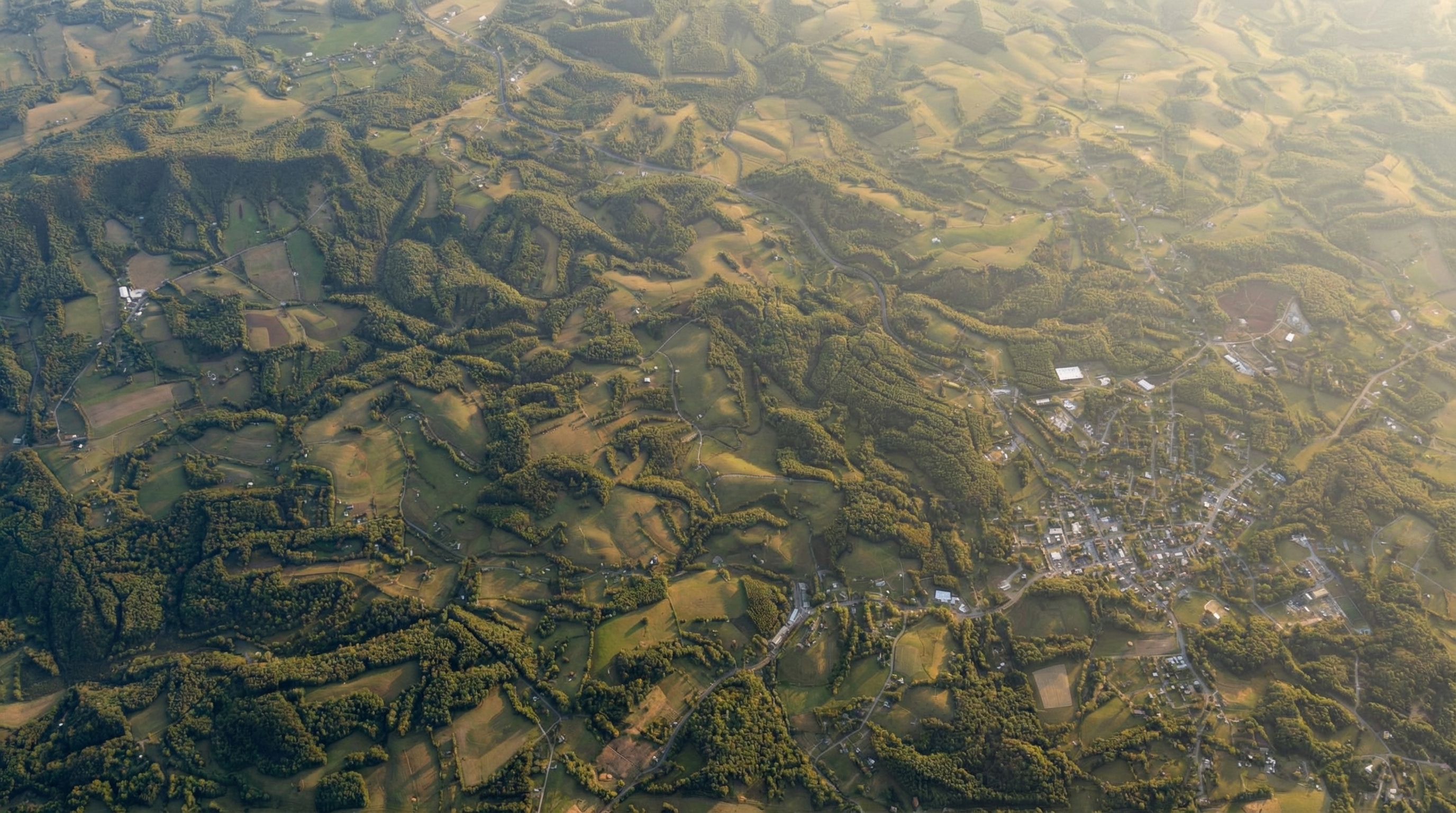 Wide aerial view of Floyd County pastures, winding roads, and Blue Ridge ridgelines