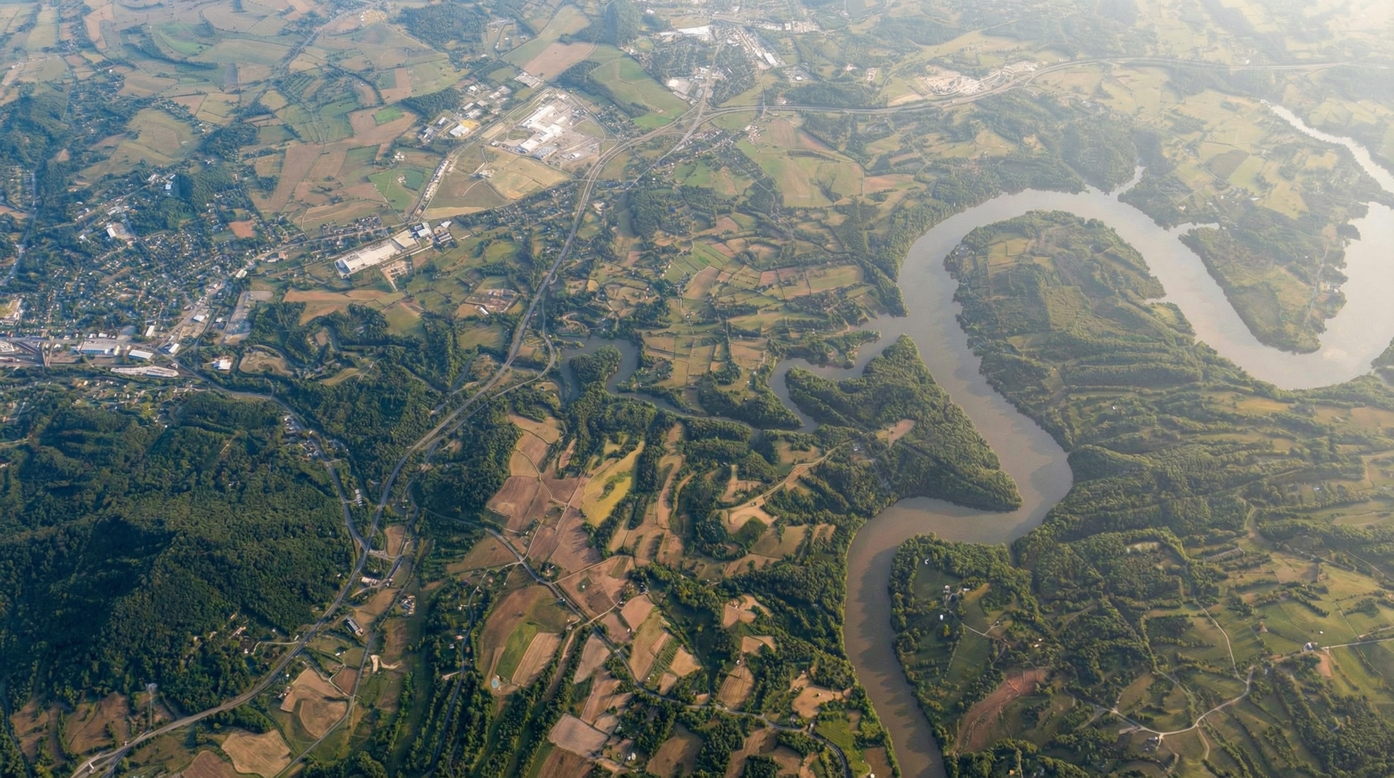 Wide aerial view of Pulaski County neighborhoods, open countryside, and water-backed ridges