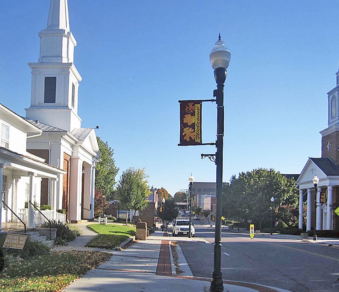 Wide view of Christiansburg neighborhoods, commercial corridors, and blue ridges beyond