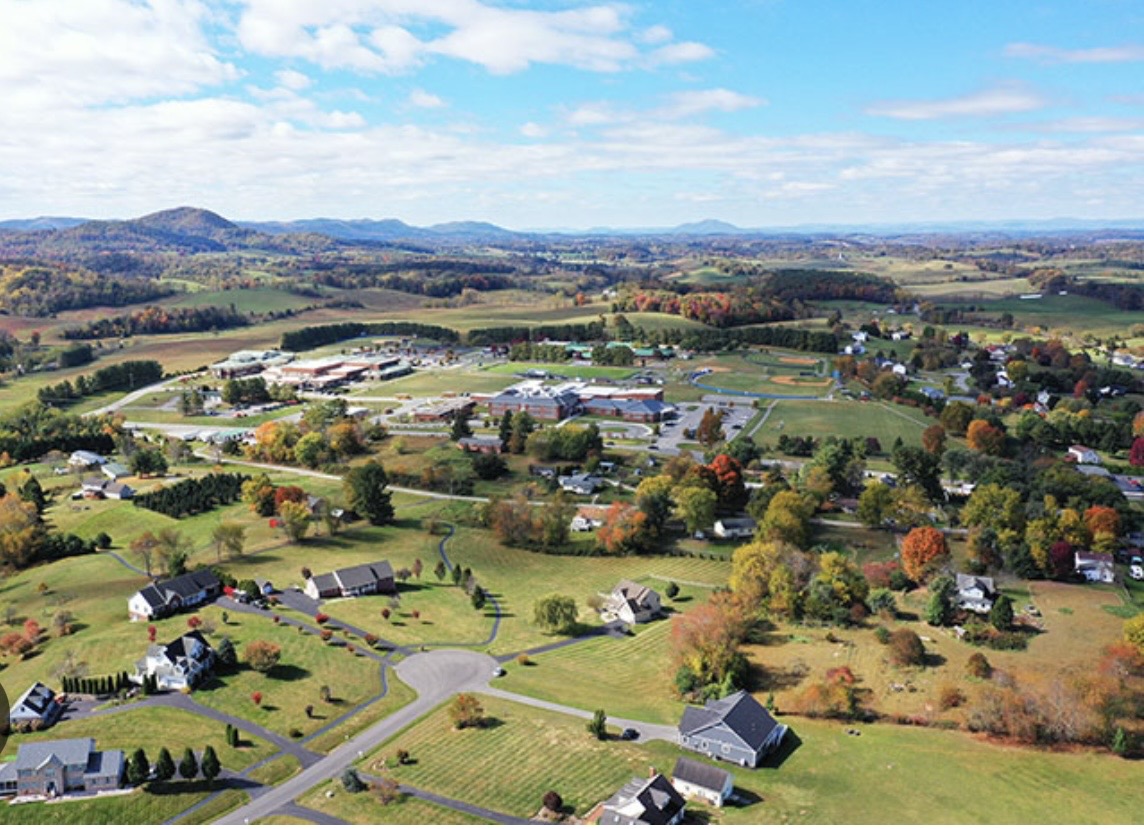 Wide aerial view of Montgomery County neighborhoods, farmland, and blue ridges